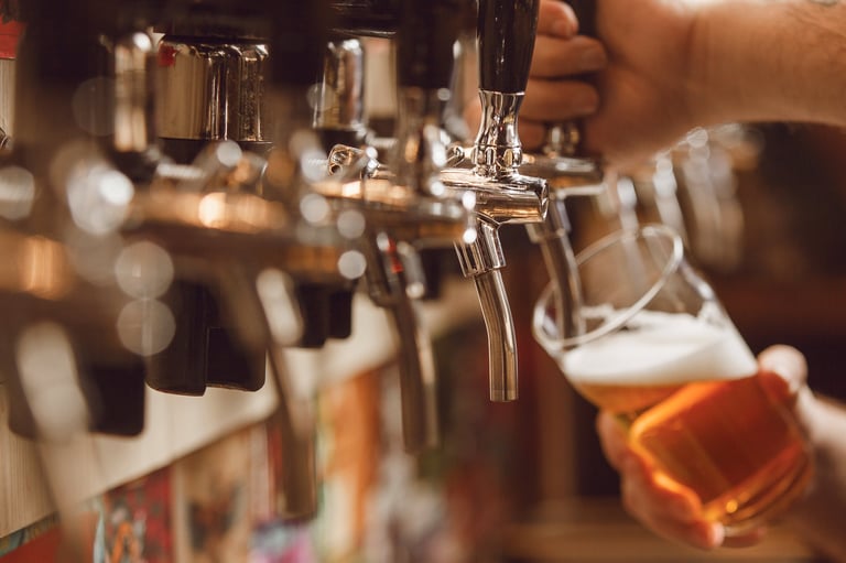 Bartender filling glass with beer from tap